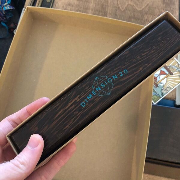 A dark Wyrmwood crafted wooden dice vault featuring the Dimension 20 branding and signed by the cast.