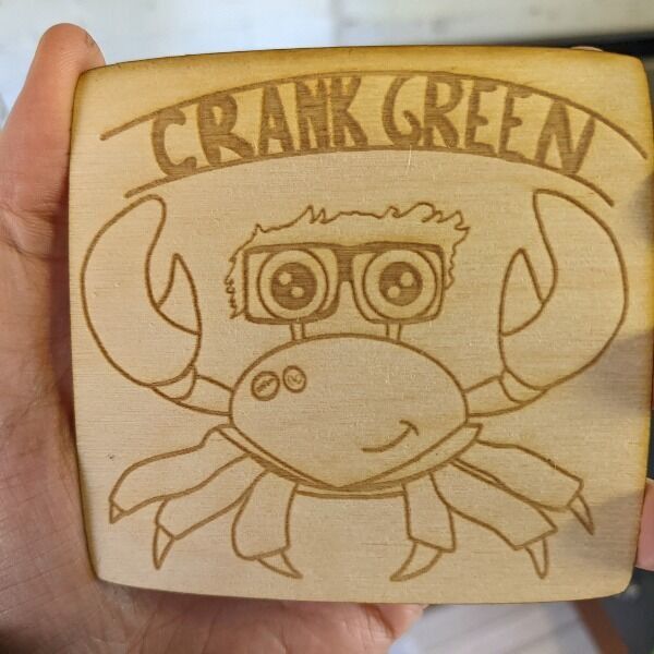 A Crank Green coaster produced by Jim and designed by FFBX (nerdfighteria discord). Photo is an unfinished sample.